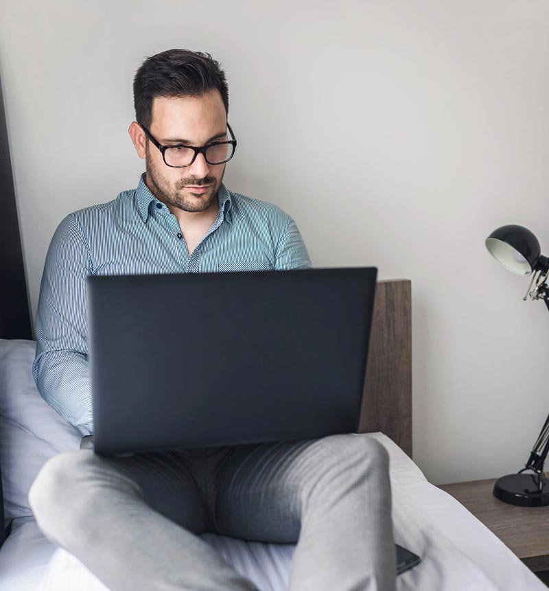 Man on bed with laptop